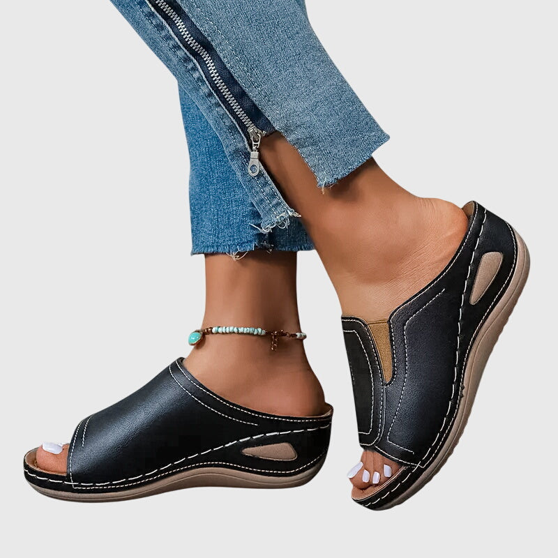 Tan open-toe wedge slides with a smooth one-piece upper and a cushioned wedge sole.