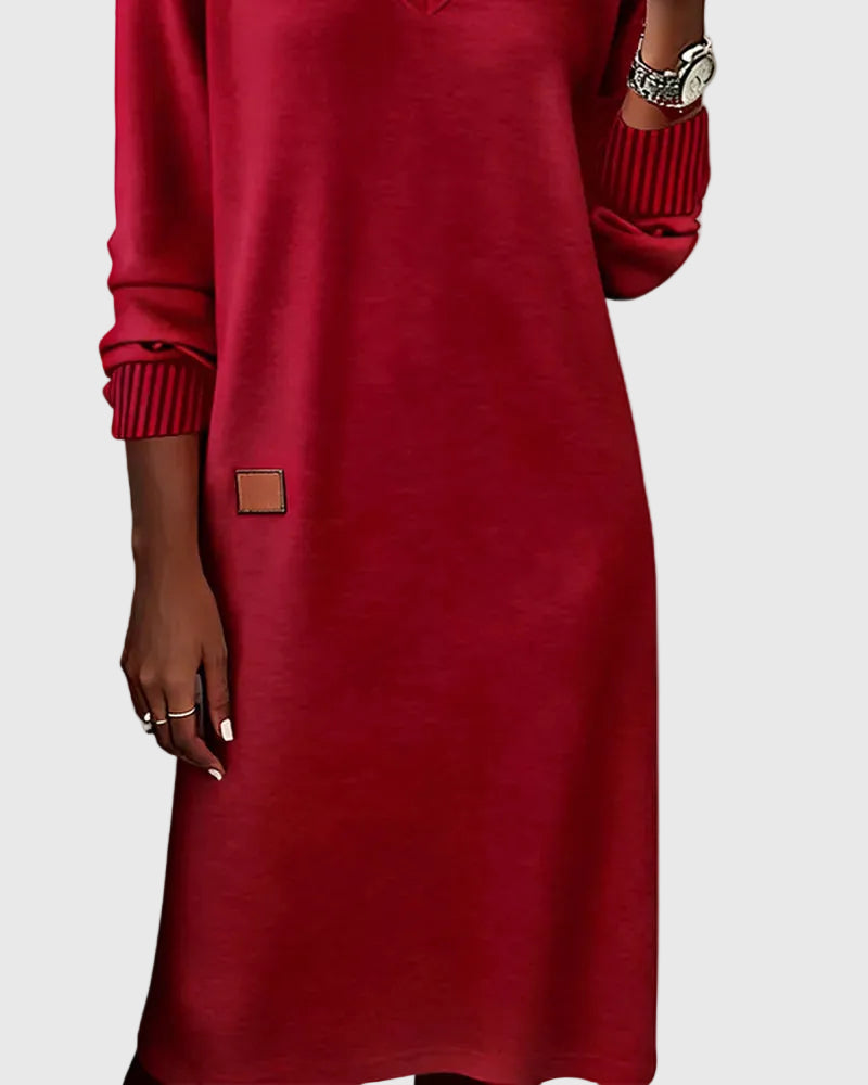 Woman wearing the Susan flowing elegant dress in beige, standing relaxed and smiling.