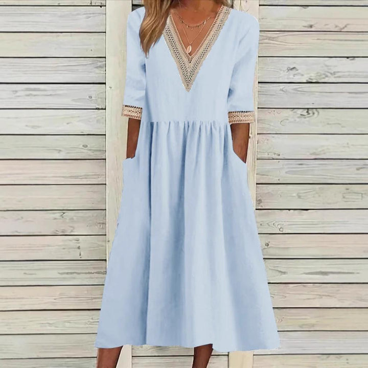 A woman wearing the Anne V-neck midi dress with delicate detailing at the collar and sleeves.