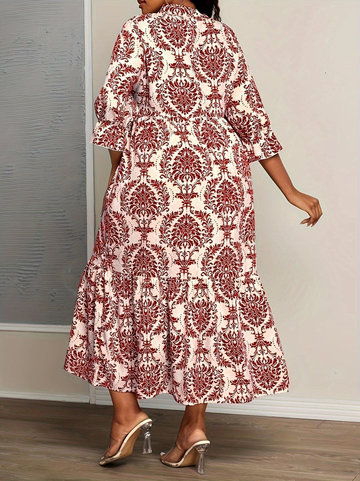 Woman strolling by the sea in the Melanie mosaic print maxi dress with a keyhole neckline and bow detail.