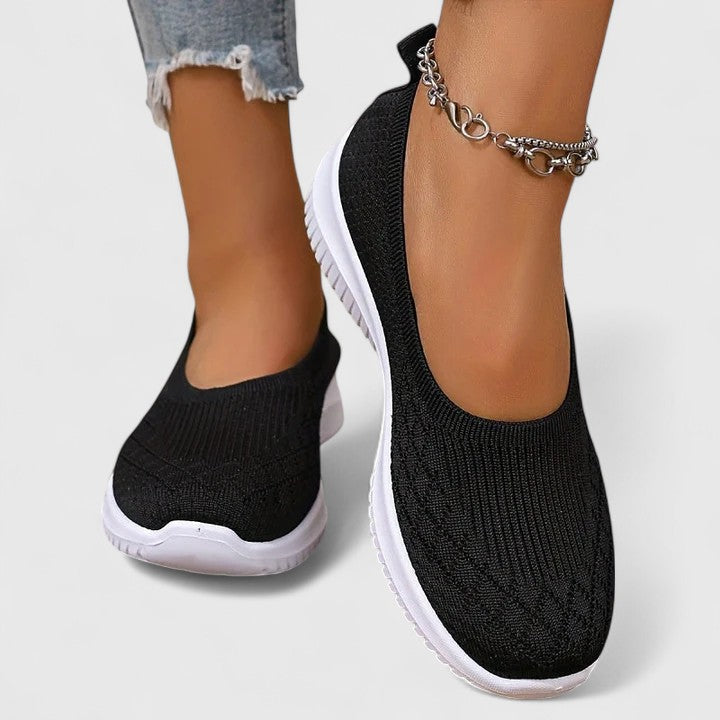 A woman slipping into soft cushioned orthopaedic slip-on shoes