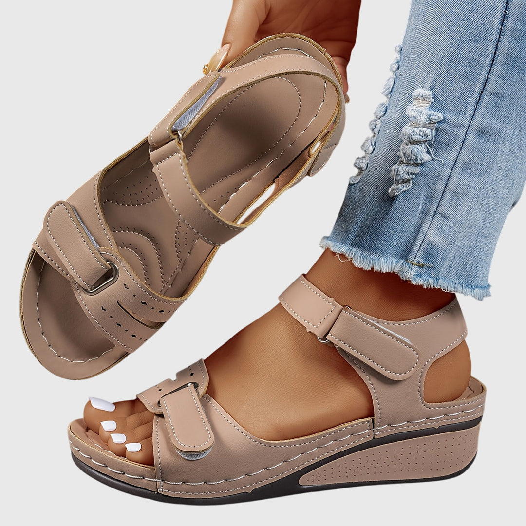 A woman wearing wide-fit supportive sandals with a relaxed summer outfit, walking with ease and confidence.