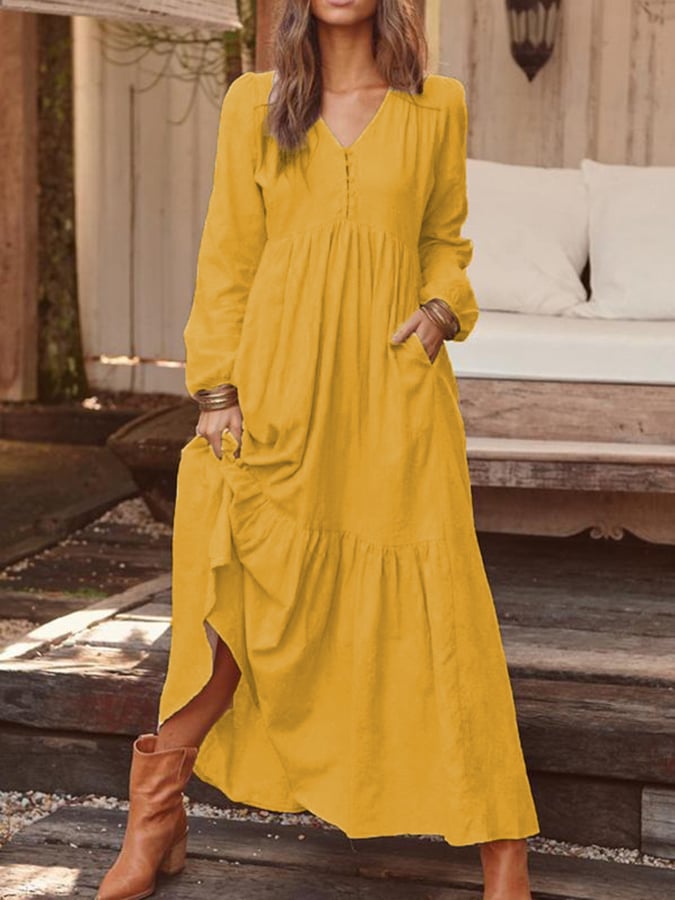 Woman walking through the countryside in the Veronique tiered maxi dress with long sleeves and a flowing flounced hem.
