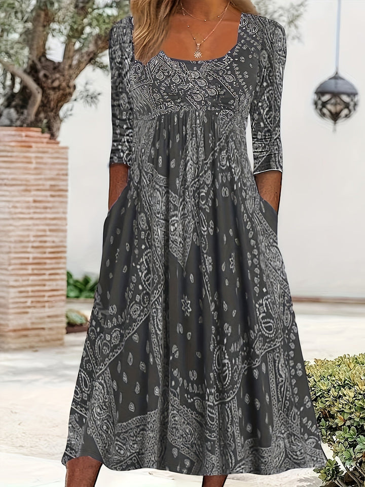 A woman wearing the Maria long sleeve grey paisley midi dress with a square neckline and flowing skirt, styled for a relaxed day out.