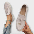 A woman wearing elegant loafers on a polished day out in the city.