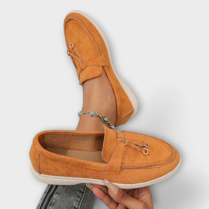 A woman wearing elegant loafers on a polished day out in the city.