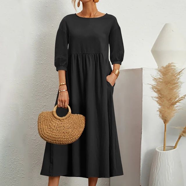 A woman wearing the Barbara fitted waist midi dress with three-quarter sleeves and a flowing skirt.