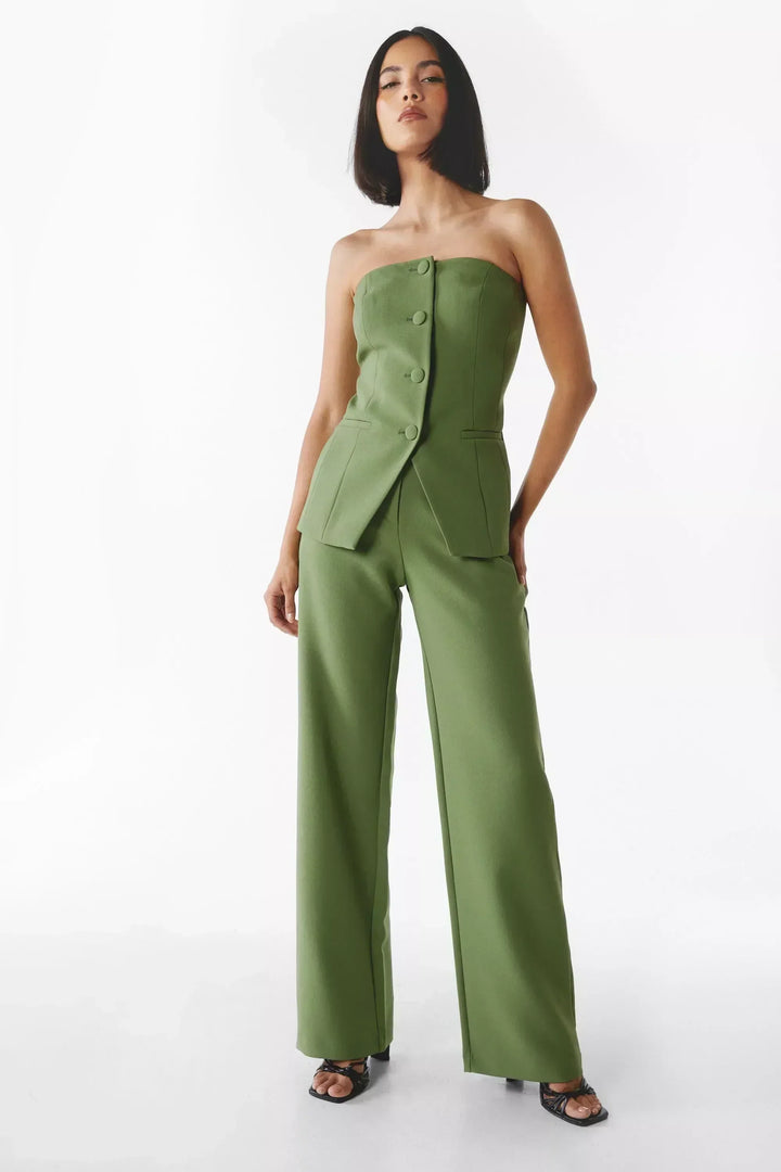 A woman wearing a tailored sleeveless button-detail top with matching wide-leg pants.
