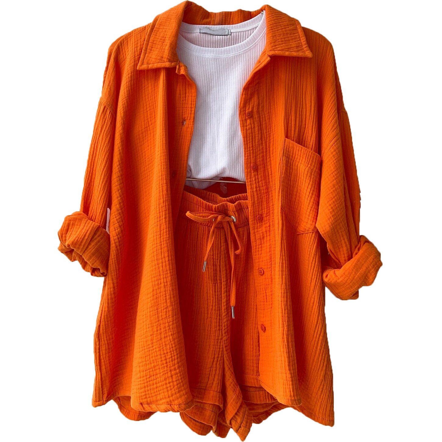 A woman wearing a relaxed button shirt with matching drawstring shorts, fresh and easy.