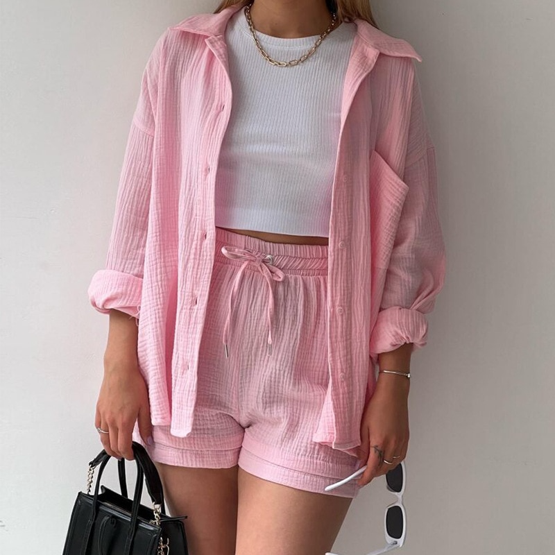 A woman wearing a relaxed button shirt with matching drawstring shorts, fresh and easy.