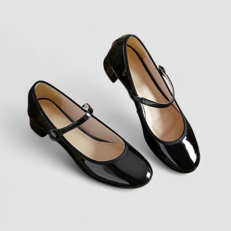 A woman wearing glossy black Mary Jane shoes with a low block heel, comfortable and steady during a day of errands.