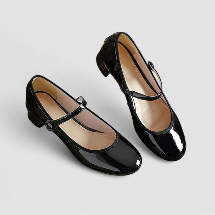 A woman wearing glossy black Mary Jane shoes with a low block heel, comfortable and steady during a day of errands.