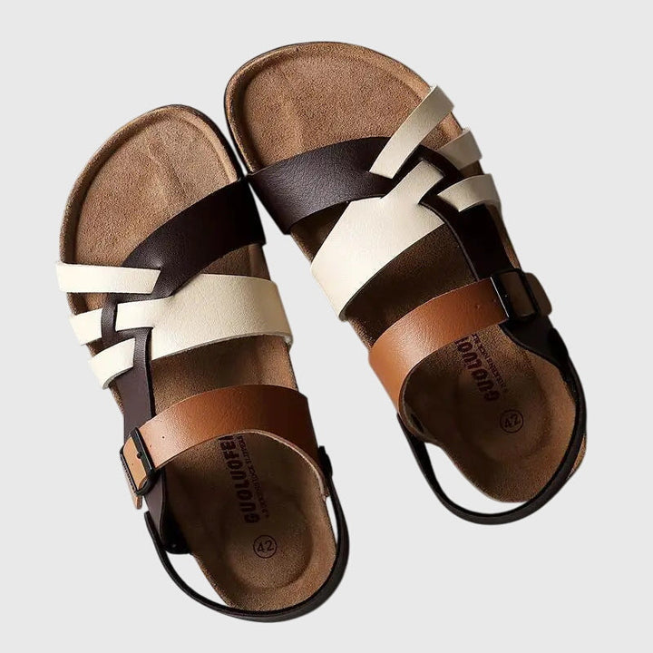 A woman in colourful cross-strap summer sandals with an adjustable ankle buckle on a warm day.
