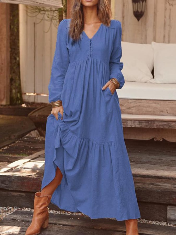 Woman walking through the countryside in the Veronique tiered maxi dress with long sleeves and a flowing flounced hem.