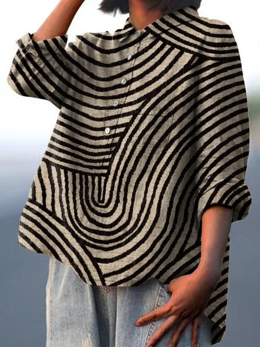 A woman wearing a beige summer blouse with a black wavy line print, looking polished and at ease on a warm day.
