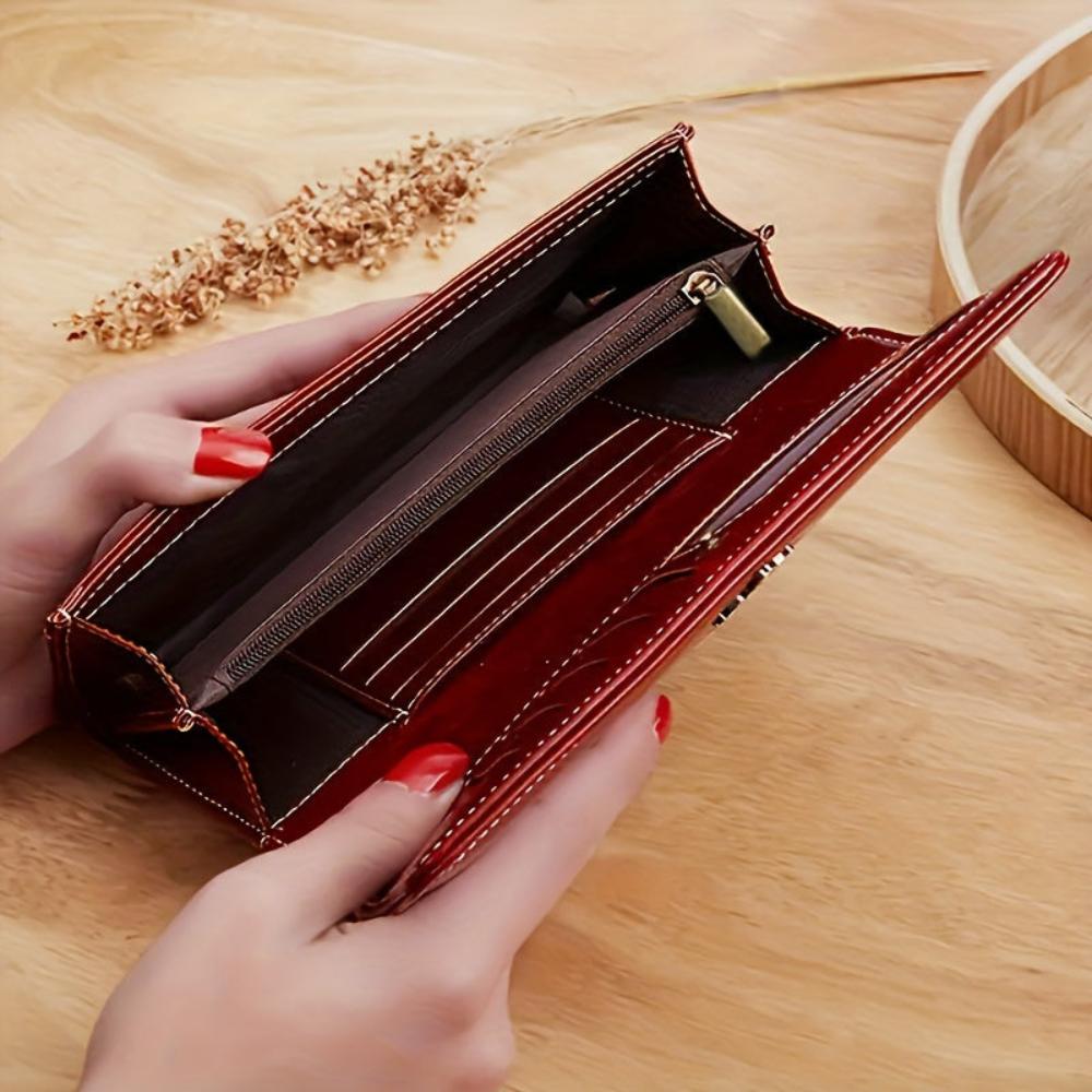 A woman holding a long flap-over wallet, tucking a card into its slot.
