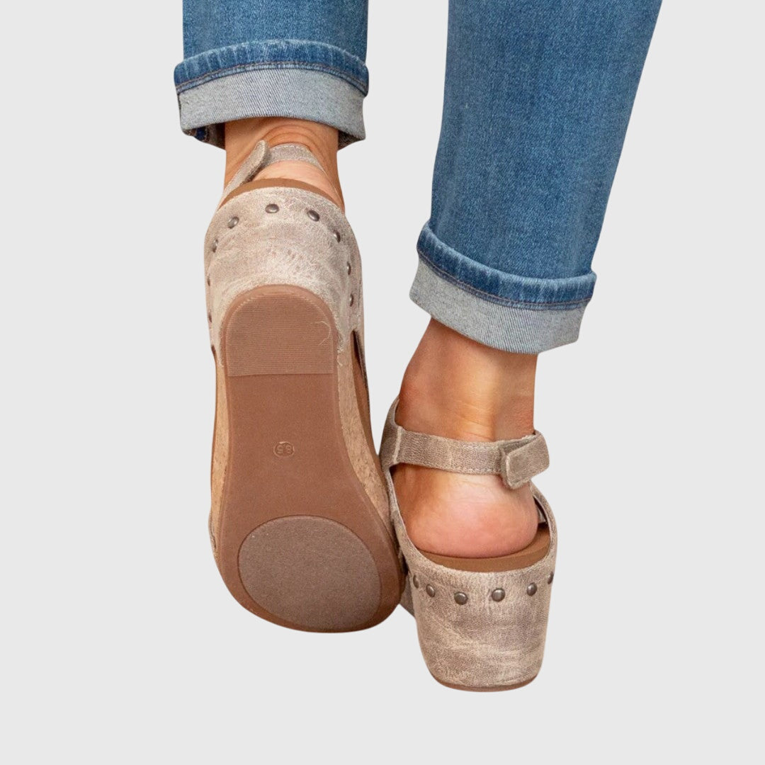 A woman in taupe wedge sandals with an open front, out shopping on a warm day.