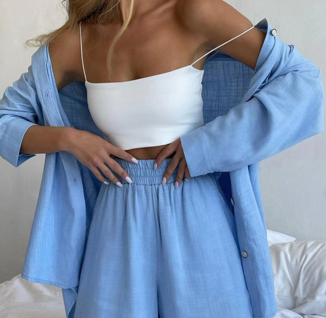 A woman wearing an oversized button-up shirt with matching high-waisted shorts.