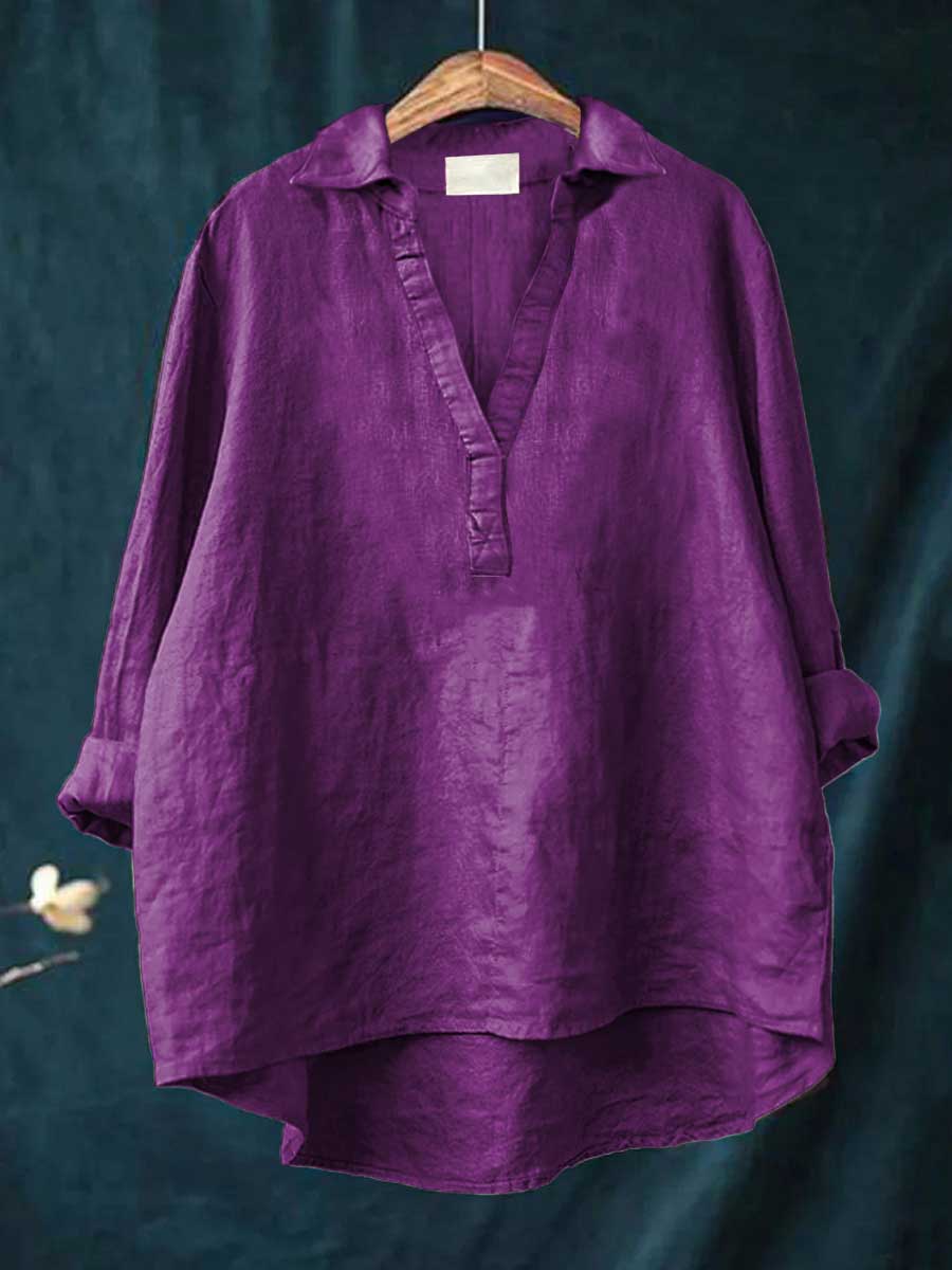 A woman wearing an elegant solid-colour summer blouse with an open V-neck, looking fresh and stylish on a warm day.