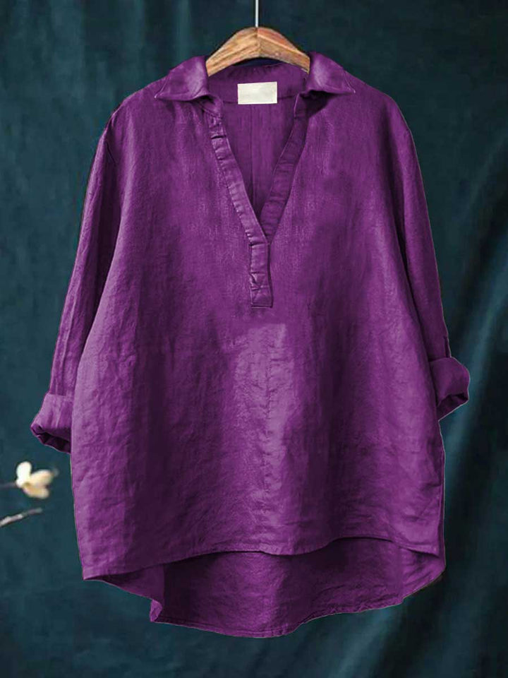 A woman wearing an elegant solid-colour summer blouse with an open V-neck, looking fresh and stylish on a warm day.