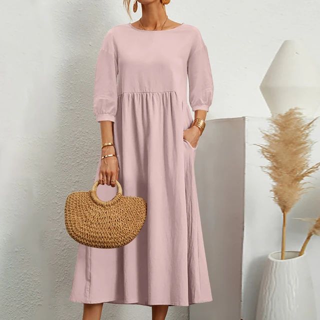 A woman wearing the Barbara fitted waist midi dress with three-quarter sleeves and a flowing skirt.