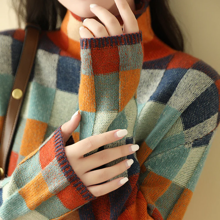 A woman wearing a colourful retro check sweater, relaxed and cosy on a cool fall morning.