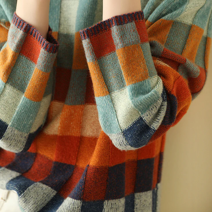 A woman wearing a colourful retro check sweater, relaxed and cosy on a cool fall morning.