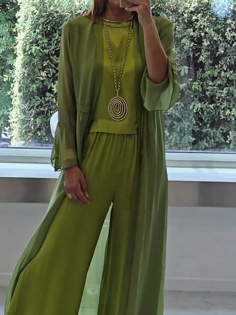 A woman wearing a flowing three-piece set with a sleeveless top, wide pants and a long cardigan.
