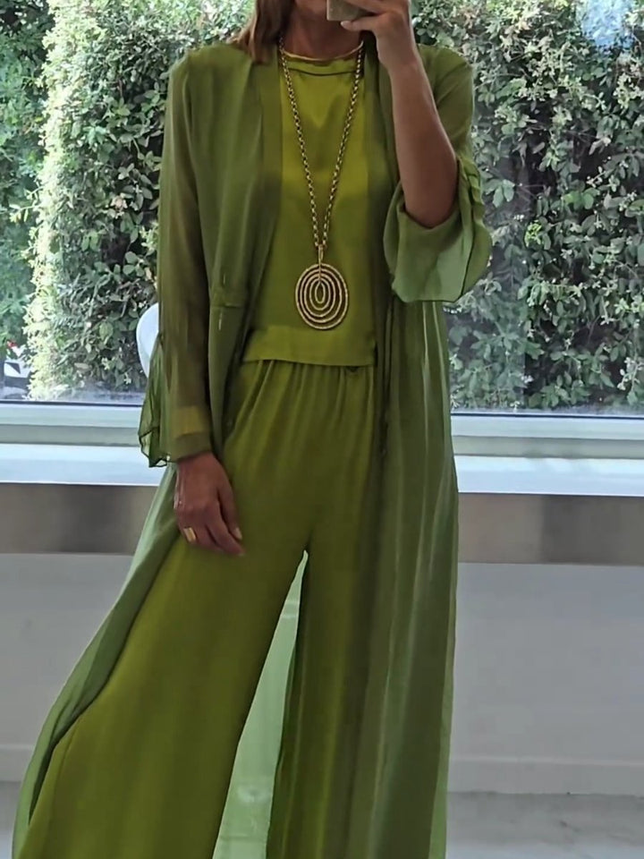 A woman wearing a flowing three-piece set with a sleeveless top, wide pants and a long cardigan.