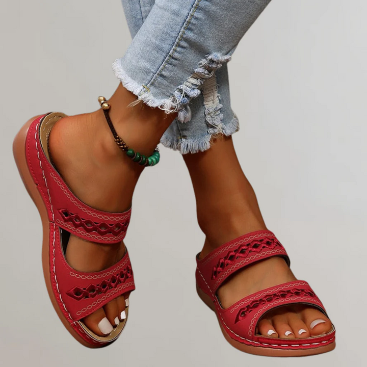 A woman walking comfortably in refined orthopaedic sandals with an adjustable strap.