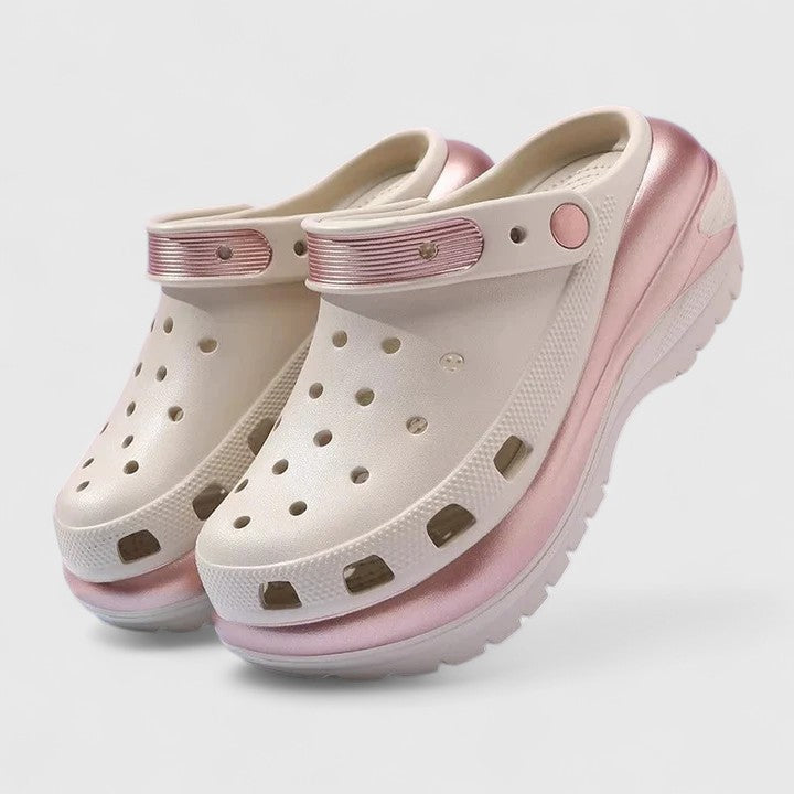 A woman walking comfortably outdoors wearing soft, cushioned orthopaedic clogs with a gentle metallic sheen.
