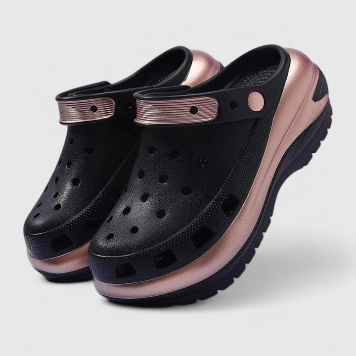 A woman walking comfortably outdoors wearing soft, cushioned orthopaedic clogs with a gentle metallic sheen.