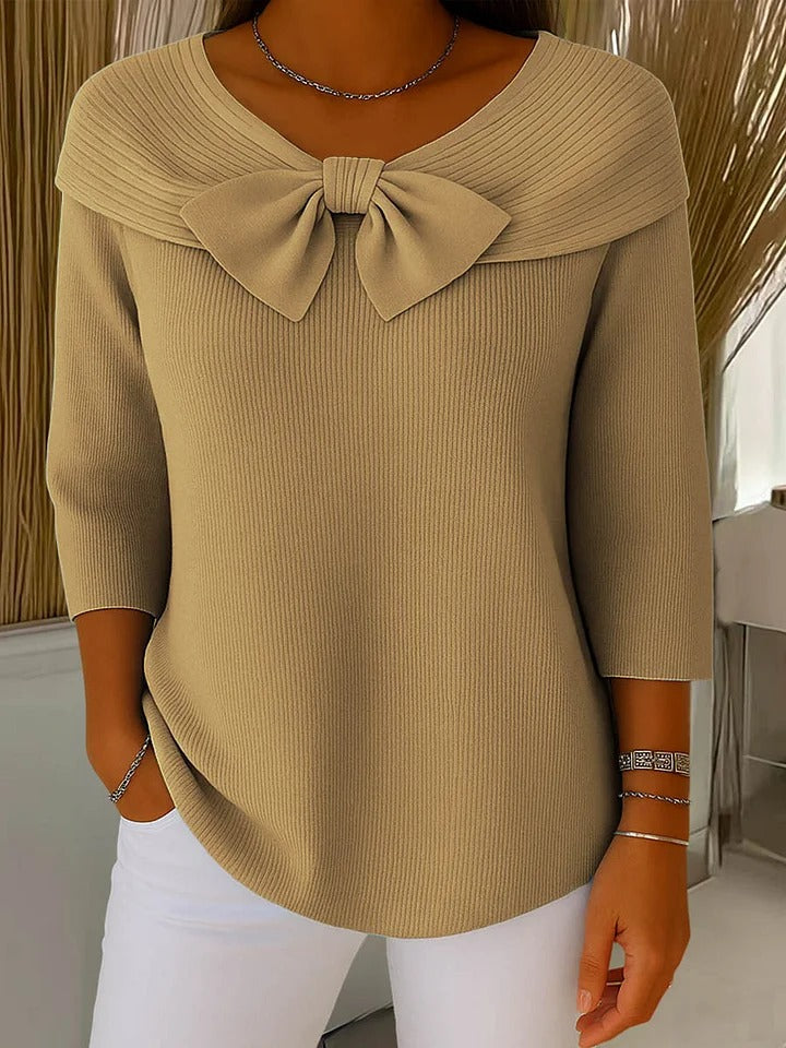 A woman wearing a shaped sweater with a soft bow detail, styled for a coffee date.