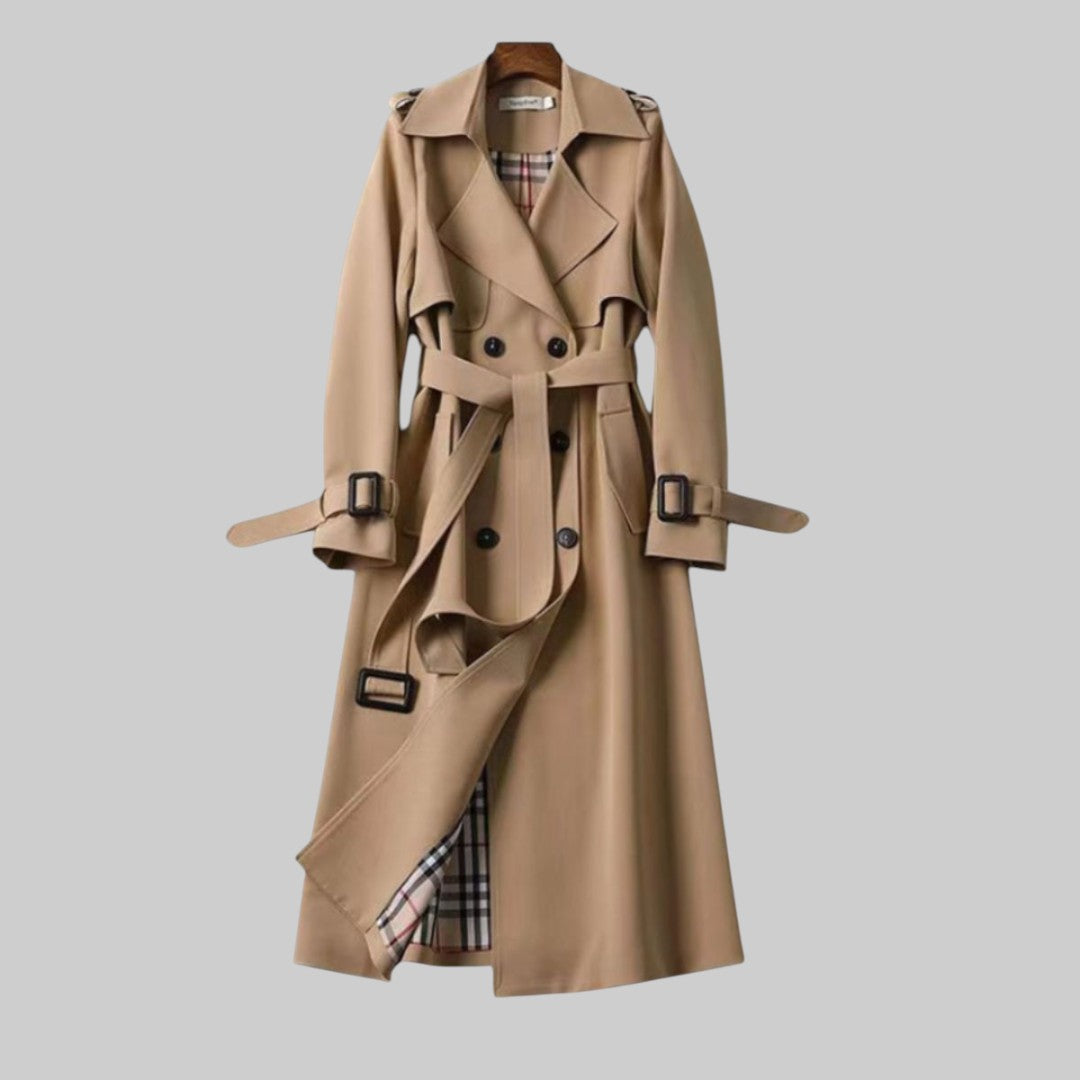 A woman wearing a belted classic trench coat with a defined waist, walking through the city.