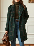 A woman wearing a dark green coat with a rust windowpane check, wide lapels and a button-through front.