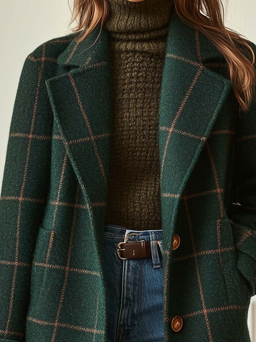 A woman wearing a dark green coat with a rust windowpane check, wide lapels and a button-through front.