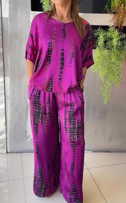 A woman wearing a vivid printed matching top and pants set.