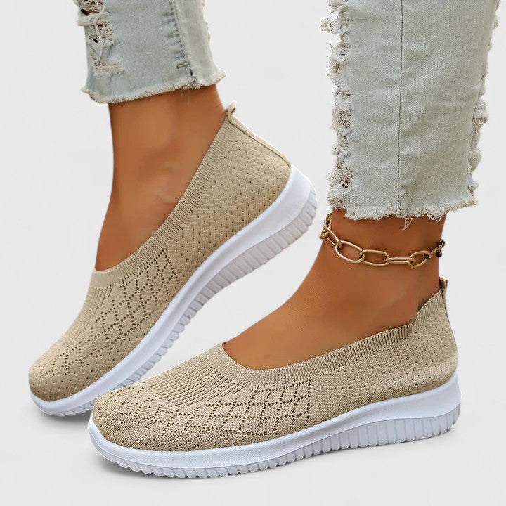 A woman slipping into soft cushioned orthopaedic slip-on shoes