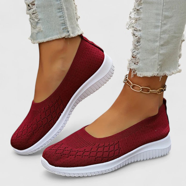 A woman slipping into soft cushioned orthopaedic slip-on shoes