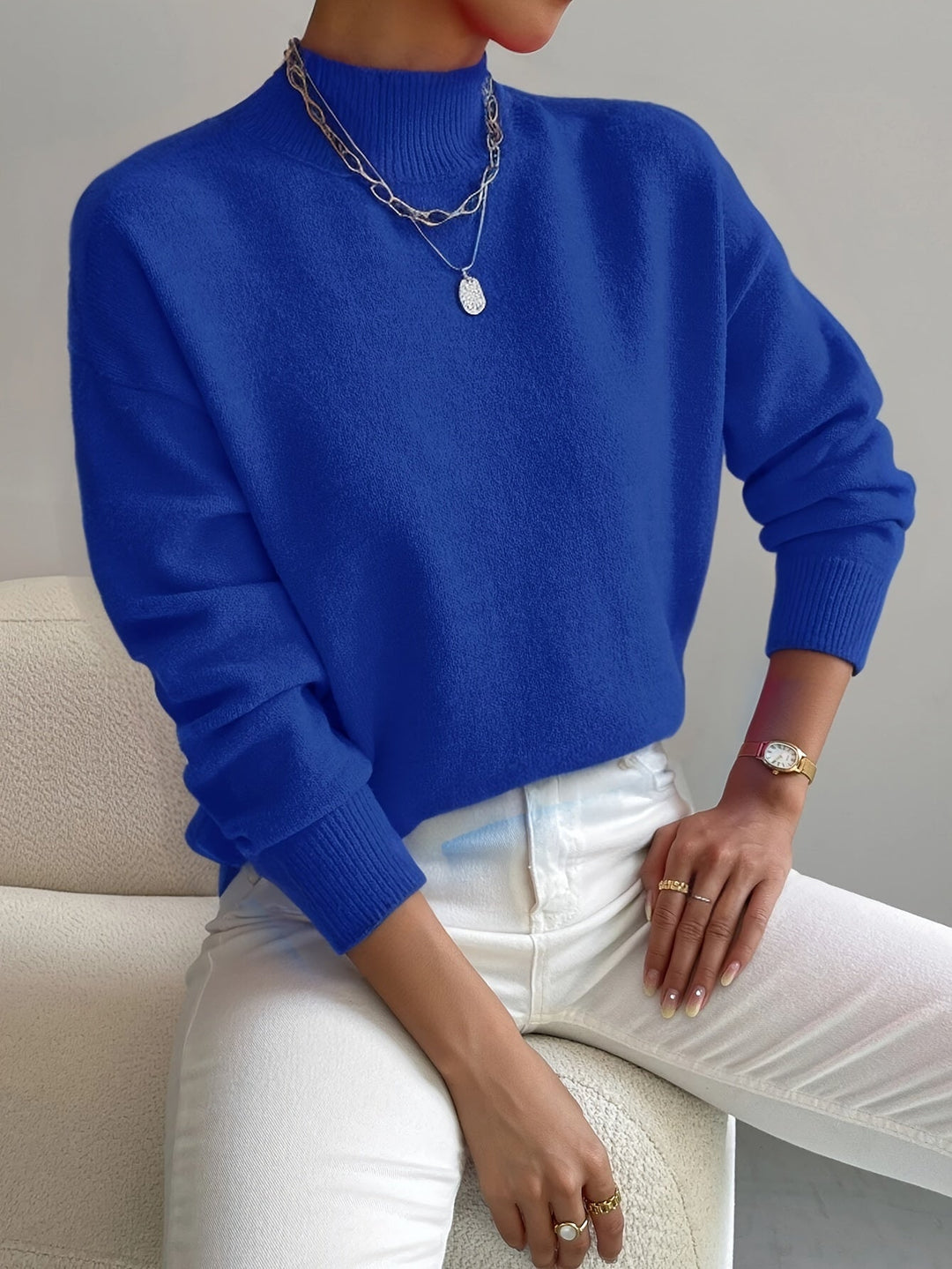 A woman wearing an elegant warm sweater with a modern stand collar, soft and refined.