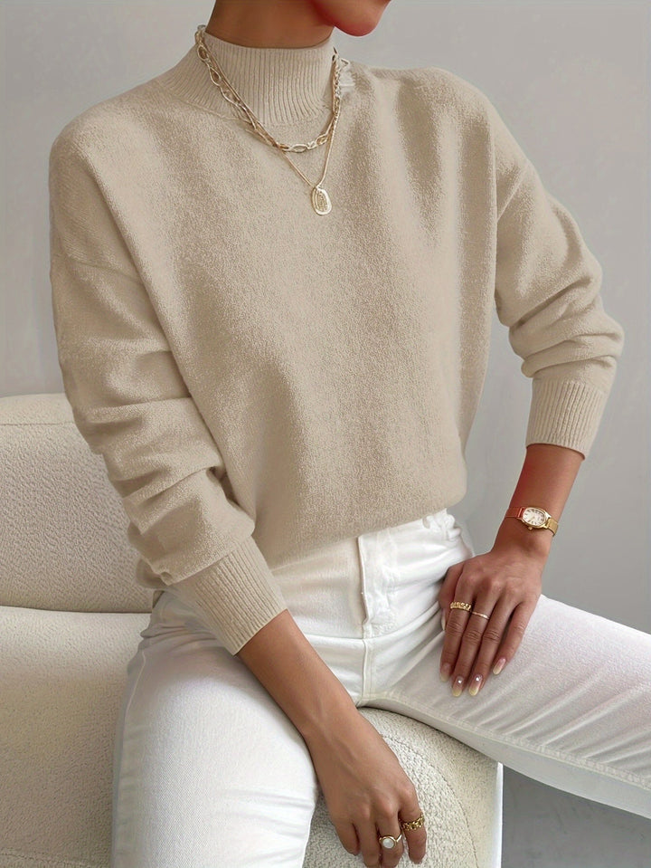 A woman wearing an elegant warm sweater with a modern stand collar, soft and refined.