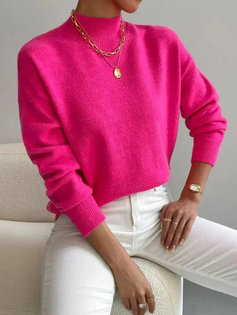 A woman wearing an elegant warm sweater with a modern stand collar, soft and refined.