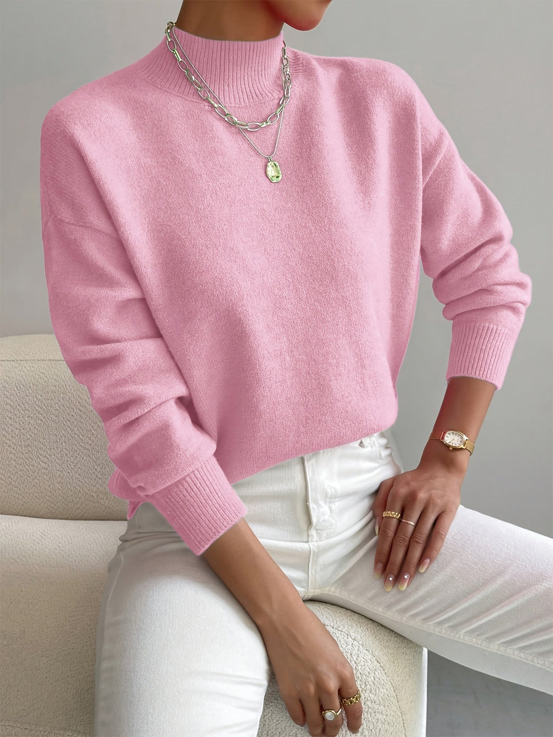 A woman wearing an elegant warm sweater with a modern stand collar, soft and refined.