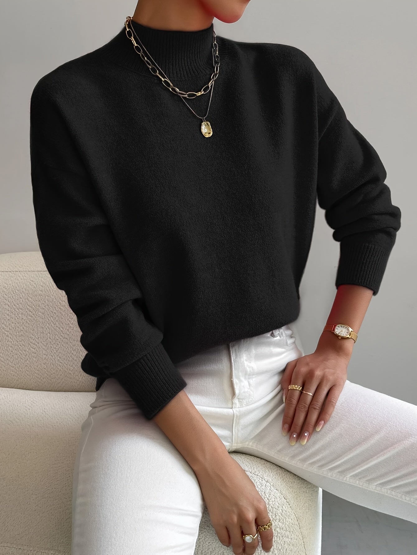 A woman wearing an elegant warm sweater with a modern stand collar, soft and refined.