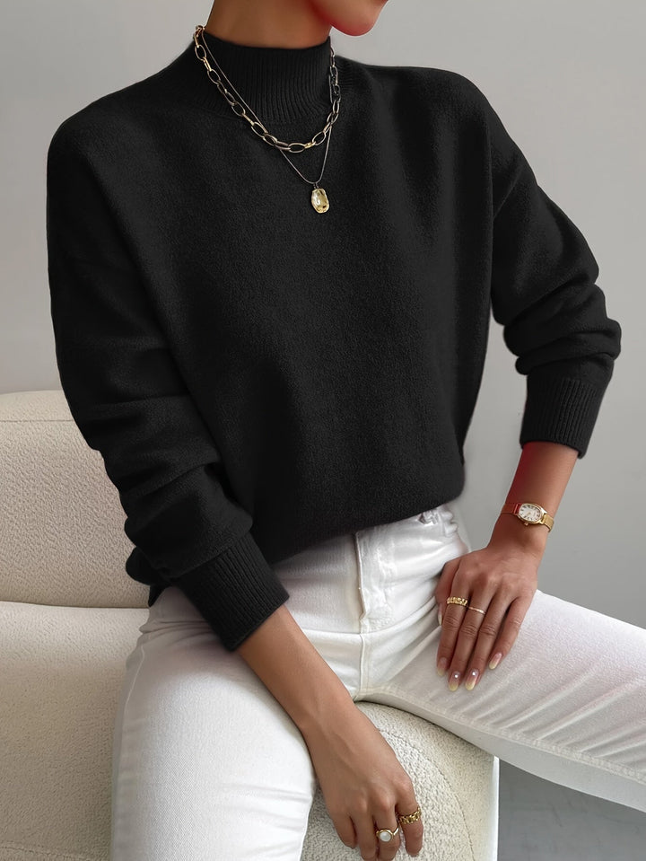 A woman wearing an elegant warm sweater with a modern stand collar, soft and refined.