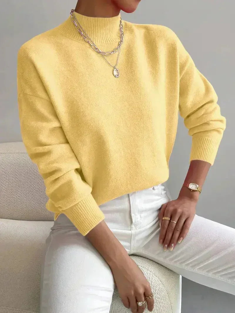 A woman wearing an elegant warm sweater with a modern stand collar, soft and refined.