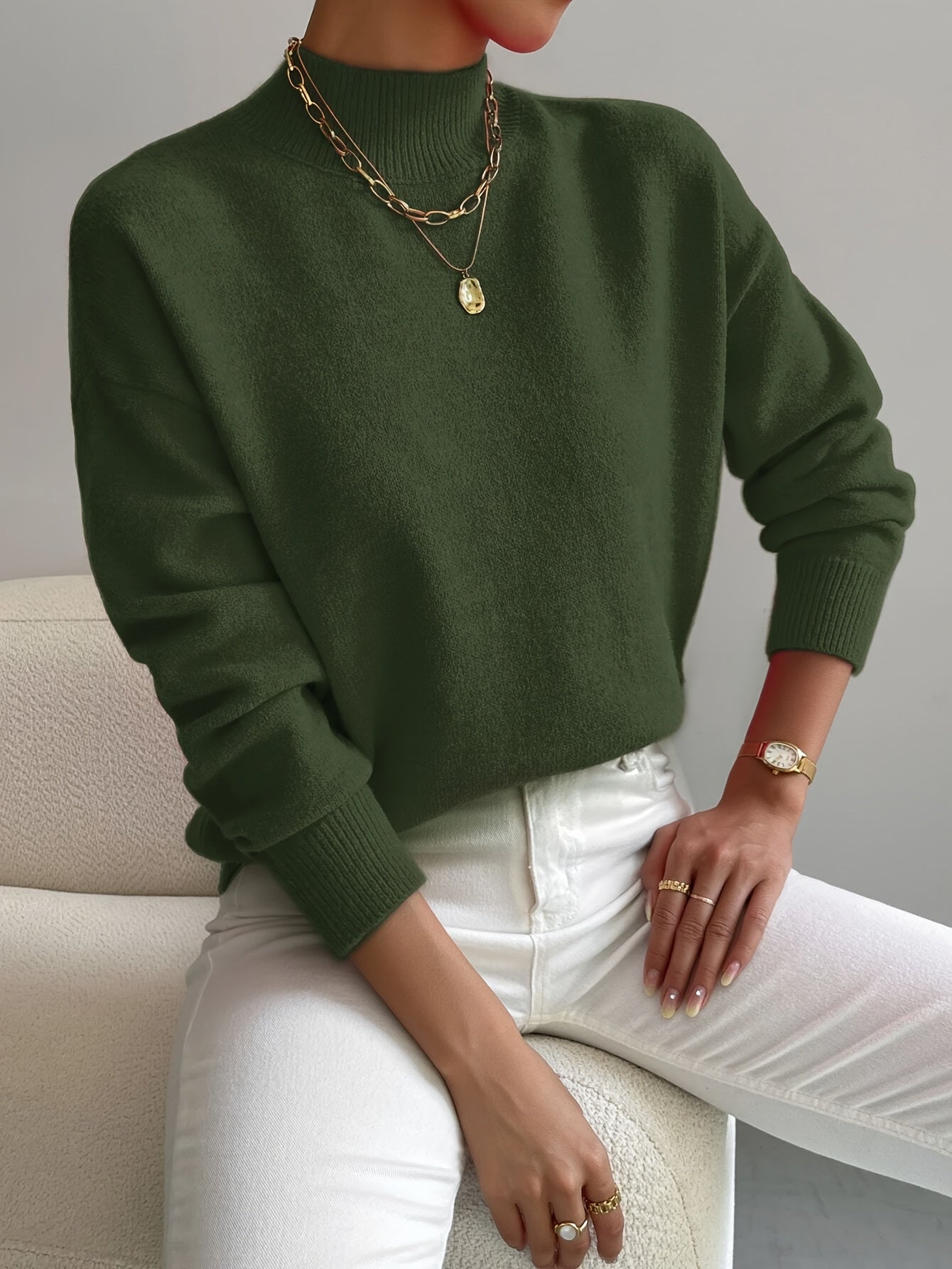 A woman wearing an elegant warm sweater with a modern stand collar, soft and refined.