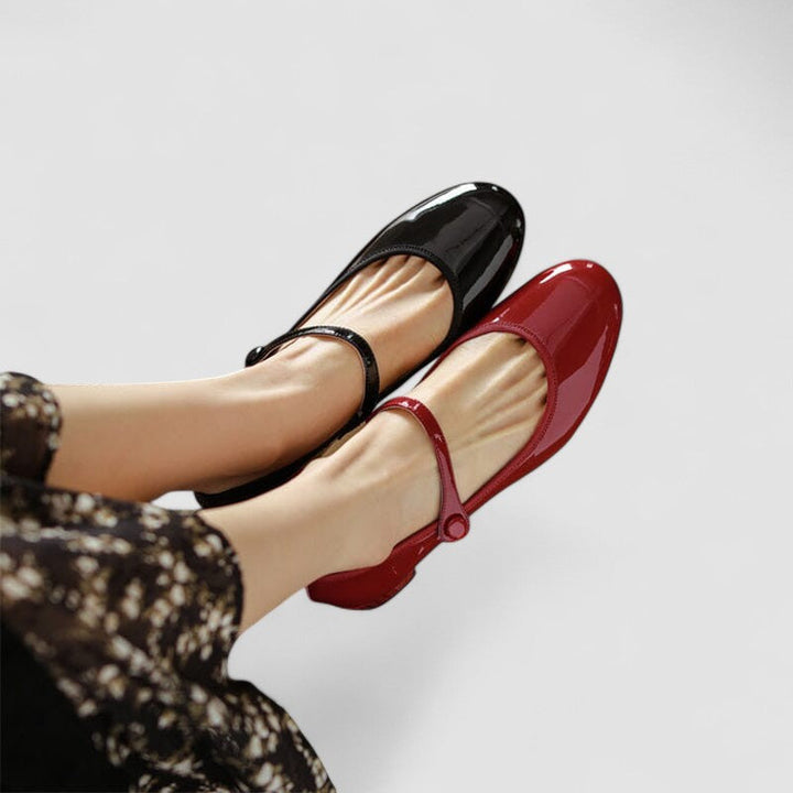 A woman wearing glossy black Mary Jane shoes with a low block heel, comfortable and steady during a day of errands.