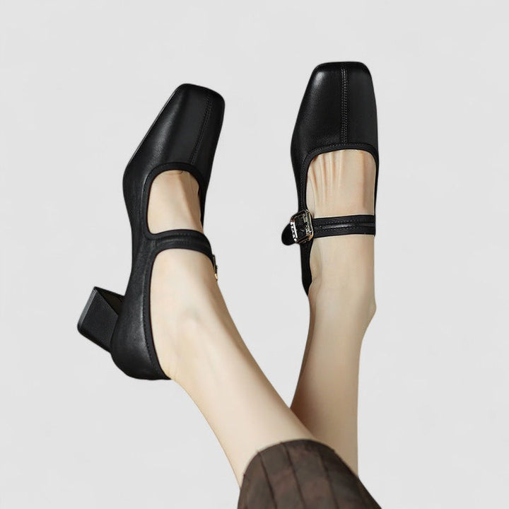 A woman in black Mary Jane shoes with a mid block heel, confident on an evening out.