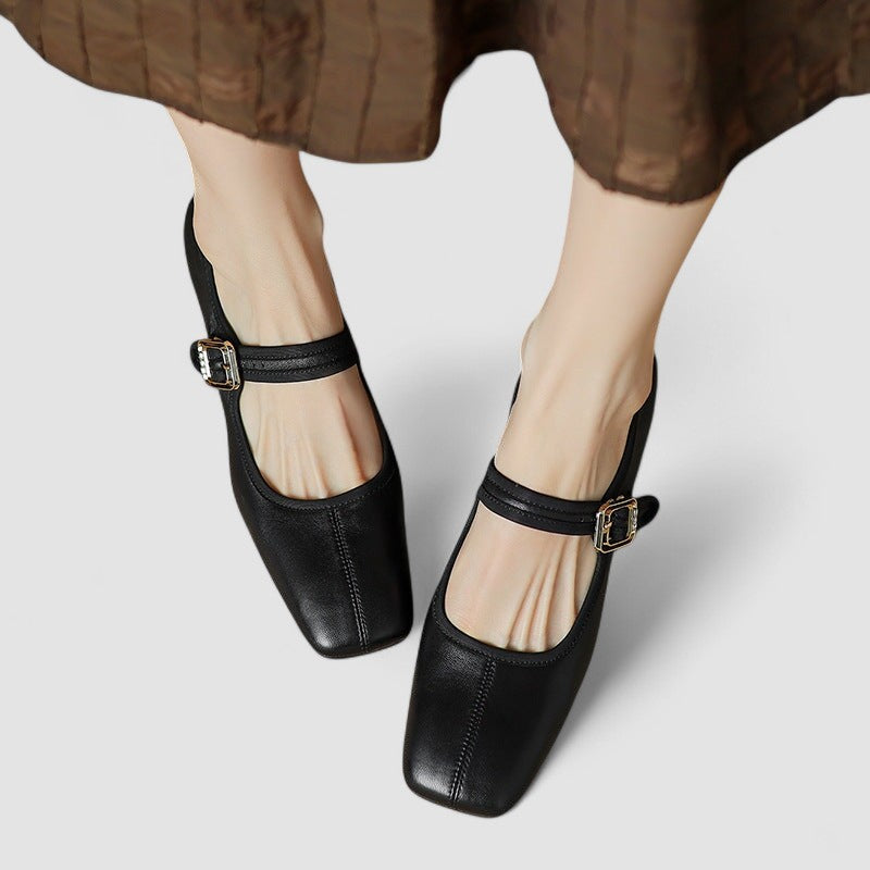 A woman in black Mary Jane shoes with a mid block heel, confident on an evening out.